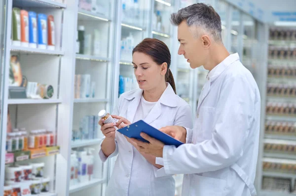 Dos farmacéuticos revisan medicamentos en una farmacia —  Fotos de Stock
