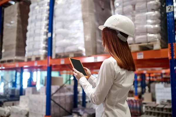 Perfil da mulher olhando para tablet no armazém — Fotografia de Stock