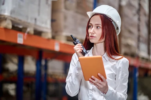 Kobieta z tabletem rozmawiająca o czasie pracy na walkie-talkie — Zdjęcie stockowe