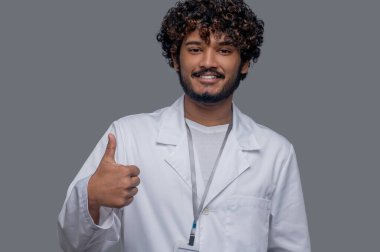 Neşeli pratisyen kameranın önünde onay işareti gösteriyor.