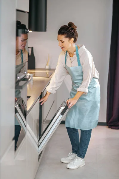 Huisvrouw in schort vullen van de vaatwasser — Stockfoto