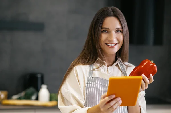 Mujer joven de pelo largo pensando en cocinar algo para el almuerzo —  Fotos de Stock