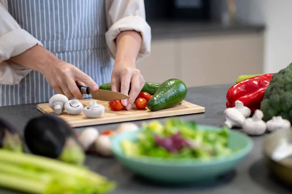 Mujer cocinando almuerzo y cortando verduras — Foto de Stock
