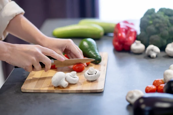 Woman cooking lunch and cutting vegetables — Stock Photo, Image