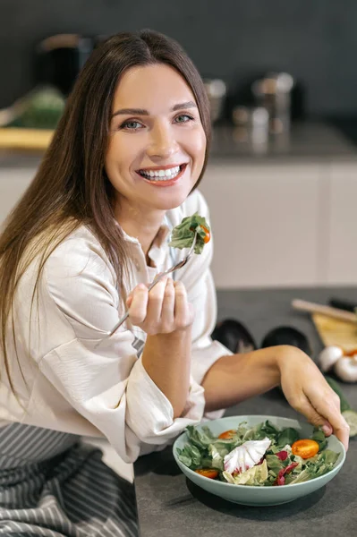 Smiling happy woman eating with appetite — ストック写真