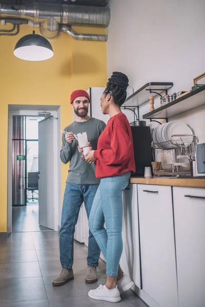 Guy and girl communicating in office kitchen — Zdjęcie stockowe