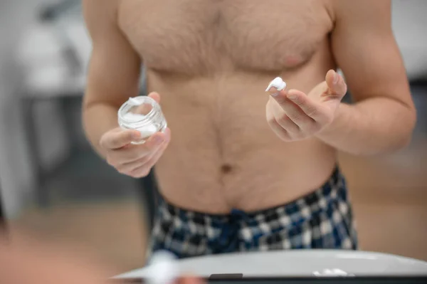 Hombre semidesnudo parado cerca del espejo y aplicándose espuma de afeitar en la cara —  Fotos de Stock