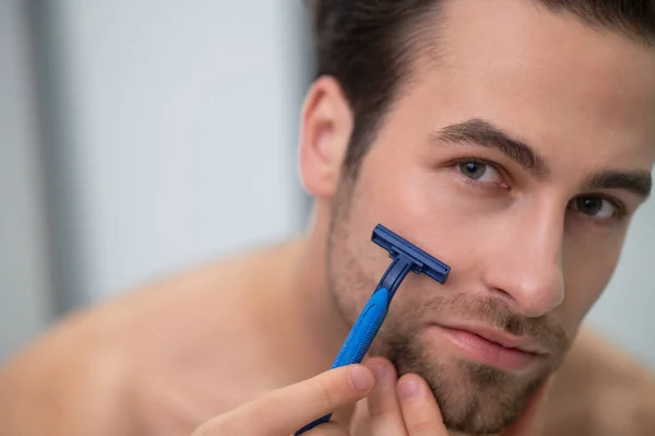 A fiatalember a tükör a borotválás — Stock Fotó