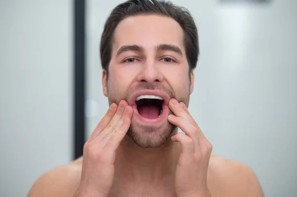 Man met open mond die zijn tanden onderzoekt — Stockfoto