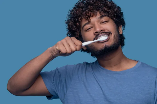 Tevreden man met behulp van een tandenborstel tijdens de tandenborstel procedure — Stockfoto