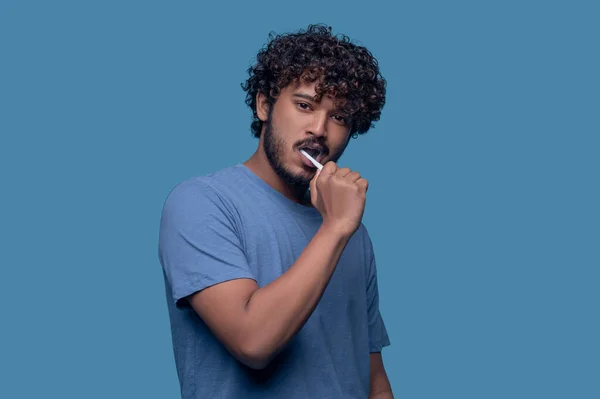 Tranquil young Indian man brushing his teeth — Stock Photo, Image