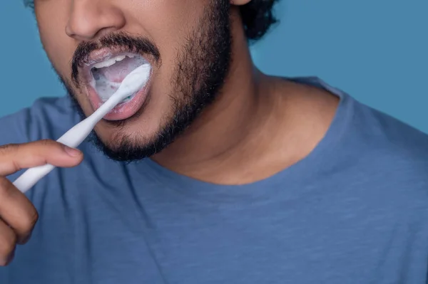 Erkek, dişlerini beyaz diş macunuyla temizliyor. — Stok fotoğraf