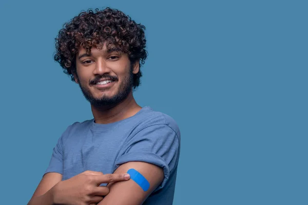 Hombre satisfecho demostrando el yeso en su brazo después de la vacunación — Foto de Stock