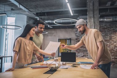 Kız ve iki erkek projeyi tartışıyor.