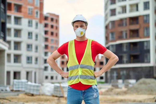 Hombre parado en el sitio de construcción mirando a la cámara —  Fotos de Stock