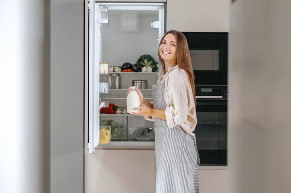 Buzdolabında yiyecek çekici genç bir kadın — Stockfoto