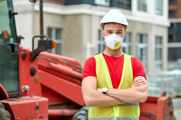 Man with folded arms looking at camera at construction site — 图库照片