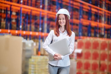 Depoda dizüstü bilgisayarlı bir kadın var.