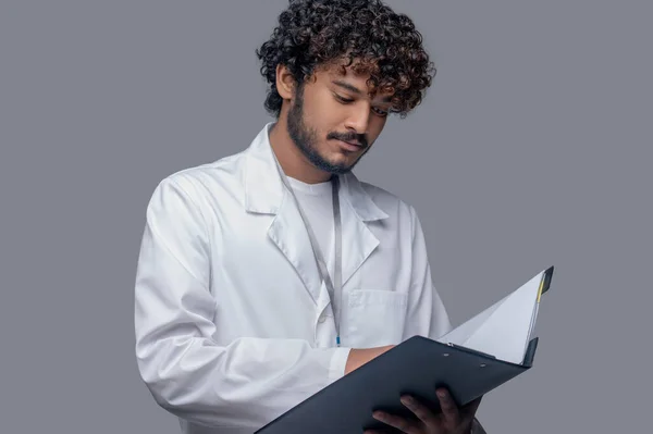 Terkonsentrasi dokter memegang dokumen di tangannya — Stok Foto