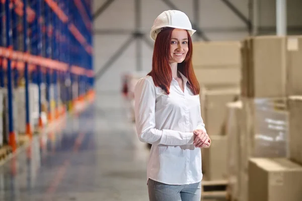 Vrouw met veiligheidshelm in magazijn — Stockfoto