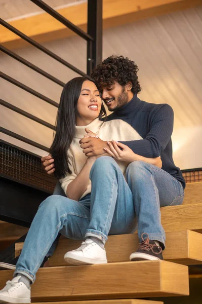 Man hugging woman sitting on stairs — Foto Stock