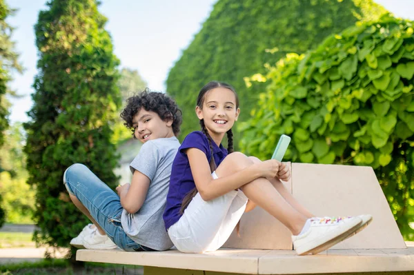 Två moderna tonåringar njuter av sin fritid i parken — Stockfoto