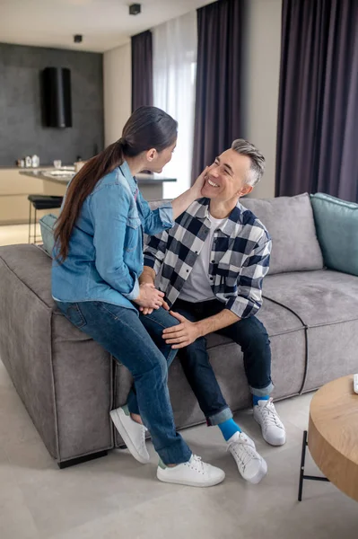 Mulher tocando rosto de homem sorridente — Fotografia de Stock