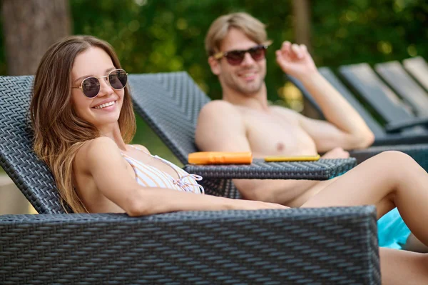 Cute young couple in sunglasses having good time together — Stock Photo, Image