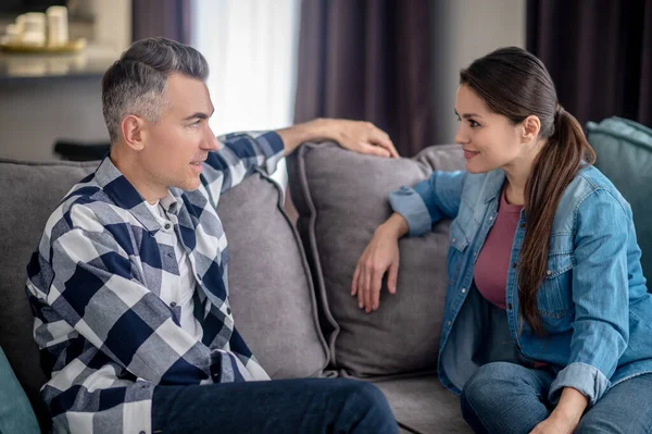 Man and woman talking sitting on couch — Fotografia de Stock