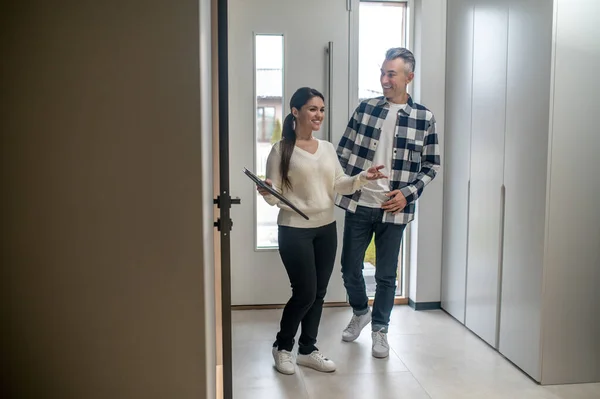 Woman with folder showing man new home — Stock Photo, Image