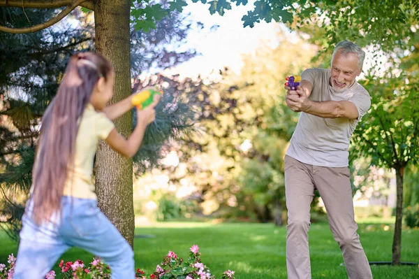 Maturo dai capelli grigi uomo giocare paintball con una ragazza — Foto Stock