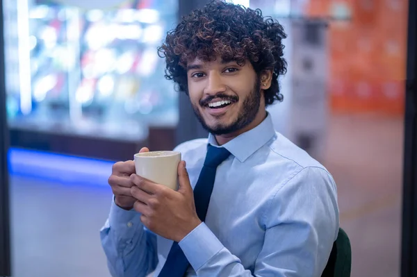 Ung elegant affärsman med en kopp i händerna — Stockfoto