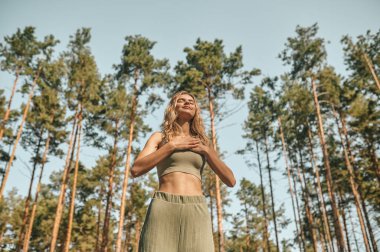 Parkta yoga yapan ve ilgili görünen bir kadın.