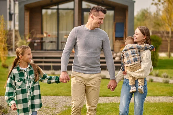 Gelukkig gezin hand in hand lopen in de tuin — Stockfoto