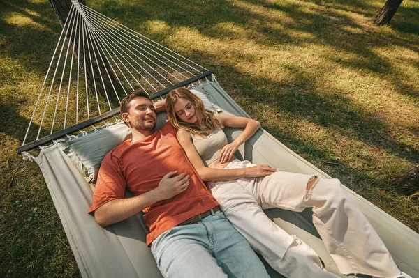 A man and a woman lying in a hammock and feeling relaxed — Stock Photo, Image