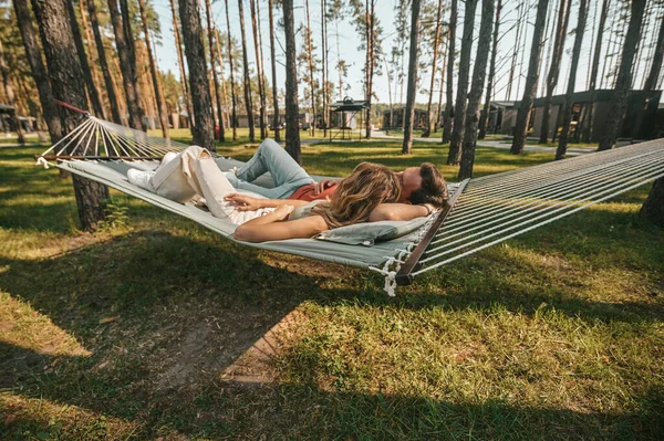 Un uomo e una donna sdraiati su un'amaca e rilassati — Foto Stock