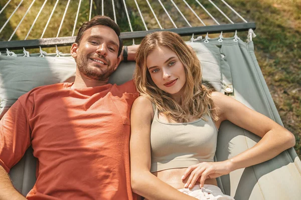 A man and a woman lying in a hammock and feeling relaxed — Stockfoto
