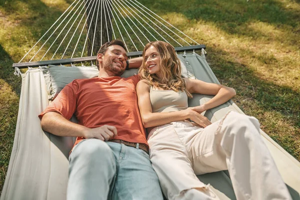 Un uomo e una donna sdraiati su un'amaca e rilassati — Foto Stock