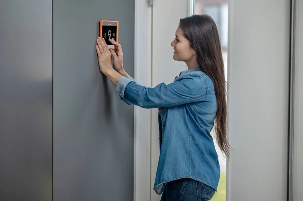 Perfil de la mujer parada cerca del dispositivo inteligente para el hogar —  Fotos de Stock