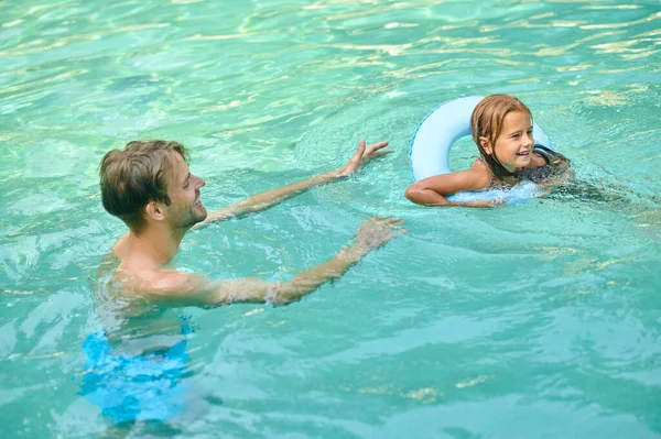 Parents teaching theri daughter to swim and looking involved — Fotografia de Stock