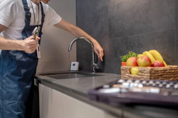 Сантехнік рука відкриває водопровідний кран на кухні — стокове фото