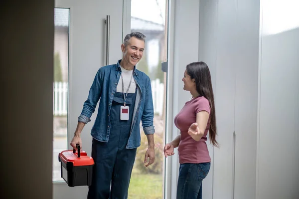 Woman inviting man to the house with tools — Stock Photo, Image
