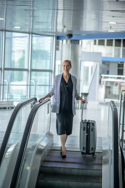 Pasajero del aeropuerto posando para la cámara en la escalera móvil — Foto de Stock