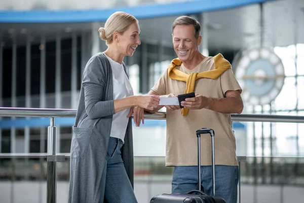 Весела пара середнього віку, що стоїть в терміналі аеропорту — стокове фото