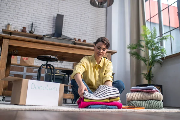 Concentrated tranquil woman packing items of clothing — Stock Fotó