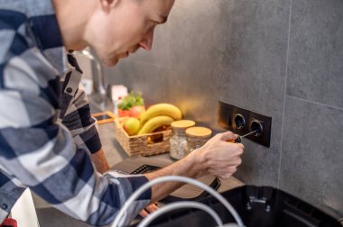 Close-up photo of man touching socket with screwdriver