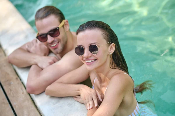 Happy man and woman spending time together in the swimming pool — Stock Photo, Image