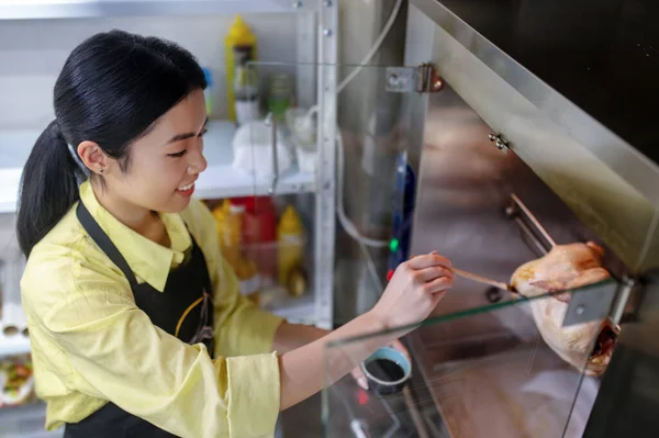 Asiática joven trabajando en la cocina y la preparación de alimentos — Foto de Stock