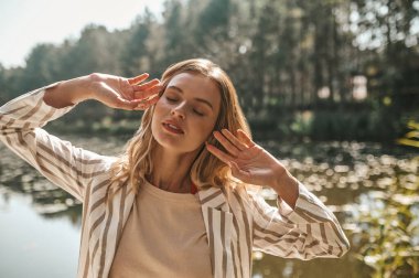 Young woman spending a day in the park near the water