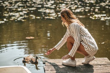 Young woman spending a day in the park near the water